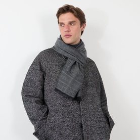 Model with Salvatore Ferragamo Monogram Jacquard Scarf in charcoal, featuring check jacquard pattern and frayed trims, styled with dark tweed coat