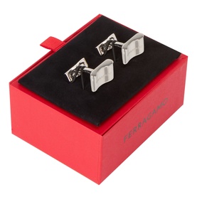 Salvatore Ferragamo silver brass cufflinks with wave-shaped face, presented in a red branded gift box with black velvet interior.