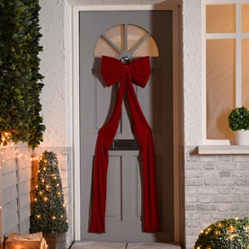 Festive Productions Long Tail Display Bow 180cm in deep red velvet-effect polyester, hung on a grey front door with trailing ribbons and silver bell