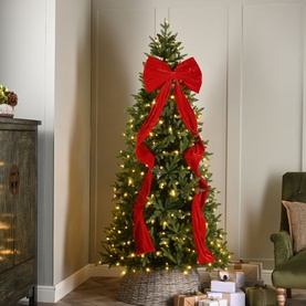 Festive Productions Long Tail Display Bow 180cm in red velvet-style polyester adorning a lit Christmas tree in a decorated living room corner