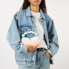 Model carrying Ganni Bou Mini Crossbody Bag in Country Air, gradient pink-blue textured finish, braided top handle, silver-tone hardware, styled with