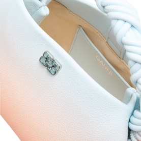 Ganni Bou Mini Crossbody Bag in Country Air, close-up of silver-tone butterfly logo on textured gradient leather exterior