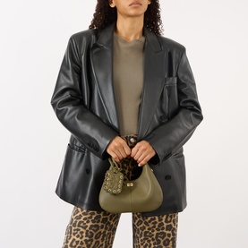 Model carrying Ganni Hobo Mini Crossbody Bag in Military Olive, gold-tone butterfly hardware, top handle, styled with black leather blazer and