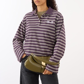 Model carrying Ganni B-Kat Logo Shoulder Bag in Military Olive, structured silhouette with gold-tone butterfly hardware and flap closure.