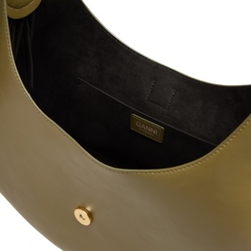 Ganni Military Olive leather shoulder bag interior view showing dark suede lining and gold-tone branded tab, with gold snap closure visible.