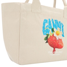 Ganni Strawberry Logo Medium Tote Bag in Sunlight canvas with strawberry graphic print and blue logo lettering, carry handles, no model.