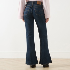Model wearing Levi's High Vibration flare jeans in dark indigo denim, shown from behind with a flared leg silhouette.
