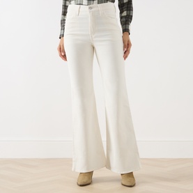 Model wearing Levi's cream flare jeans, styled with a plaid shirt and tan ankle boots