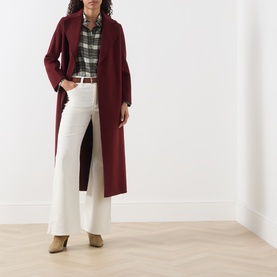 Model wearing Levi's Cream Flare Jeans with a burgundy longline coat, plaid shirt and tan heeled ankle boots