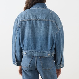 Model wearing Levi's denim jacket in Trip On Drip Trucker wash, rear view, cropped fit with stud detailing, styled with matching denim jeans