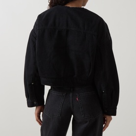 Model wearing Levis Cropped Sherpa Trucker Jacket in Slight Night black, collarless, dropped shoulders, buttoned cuffs, styled with black jeans. Back