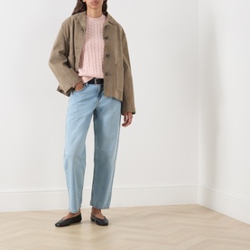 Model wearing Levi's Loose Tapered Jeans in Message Sent light wash, styled with a pink knit, khaki jacket and black ballet flats