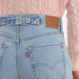 Model wearing Levis Loose Tapered Jeans in Message Sent light wash, close-up of back waistband with leather logo patch and red tab branding.
