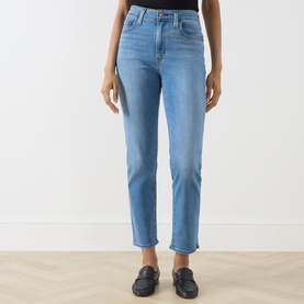 Model wearing Levi's True Blue Mid slim jeans in light blue denim, styled with black loafers
