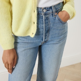 Model wearing light blue straight-leg high-rise jeans, styled with a pale yellow fluffy cardigan and white top