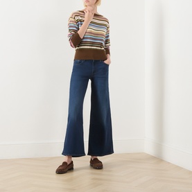 Model wearing Levi's True Blue Dark Wide Leg jeans, styled with a multicolour stripe knit and brown loafers.
