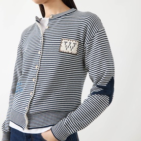 Model wearing Max Mara Weekend Teiera Stripe Cardigan in navy pinstripes with badge embellishment, styled over a white top with jeans.