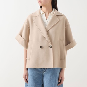 Model wearing Max Mara Weekend Neo Double-Breasted Peacoat in sand, short sleeves with turned-up cuffs, styled with blue jeans