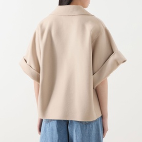 Model wearing Max Mara Weekend Neo Double-Breasted Peacoat in sand, rear view showing turned-up cuffs and straight hemline, styled with blue jeans