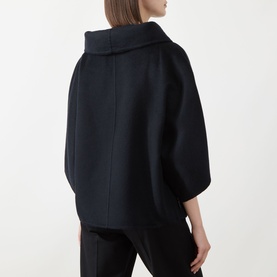 Model wearing Max Mara Main ultramarine cashmere coat, rear view, oversized silhouette with wide collar and three-quarter sleeves, styled with black