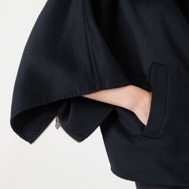 Model wearing Max Mara Main ultramarine cashmere coat, close-up of side seam pocket and wide sleeve detail.