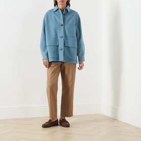 Model wearing Max Mara Weekend light blue wool coat with patch pockets, styled with tan trousers and brown loafers