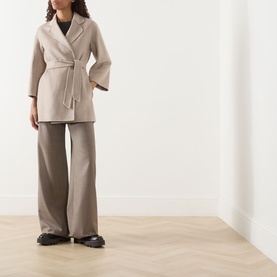 Model wearing Max Mara Main Detto Short Overlay Wrap Coat in sand cashmere with self-tie belt, styled with wide-leg trousers and black chunky loafers
