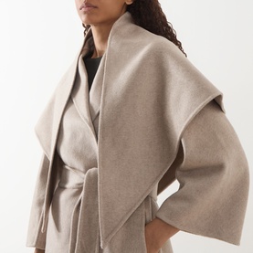 Model wearing Max Mara Main Detto Short Overlay Wrap Coat in sand cashmere, featuring shawl overlay, cropped sleeves, and self-tie belt