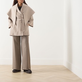 Model wearing Max Mara Main Detto Short Overlay Wrap Coat in sand cashmere with self-tie belt and shawl detail, styled with wide-leg trousers and