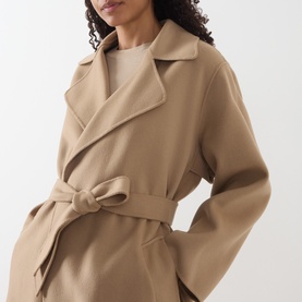 Model wearing Max Mara Weekend camel wool coat with wide lapels, belted waist, styled with a cream top.