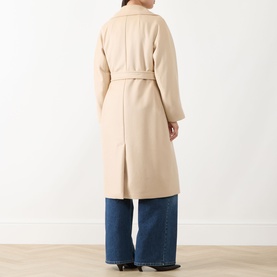 Model wearing Max Mara Weekend sand wool coat, back view, with tie belt, styled with wide-leg blue jeans.