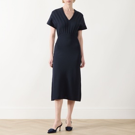 Model wearing Max Mara Main ultramarine knit dress with V-neck, short sleeves and midi length, styled with navy heeled mules.