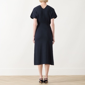 Model wearing Max Mara Main ultramarine midi dress with pleated back bodice, short sleeves, and elasticated waist, styled with black heels.
