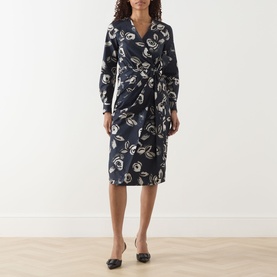 Model wearing Max Mara ultramarine floral print wrap-style midi dress with long sleeves and tie waist, styled with black flat shoes.