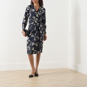 Model wearing Max Mara ultramarine cotton wrap dress with abstract print and long sleeves, styled with black ballet flats and small clutch bag.
