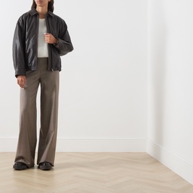Model wearing Max Mara Weekend dark brown leather jacket, styled with taupe wide-leg trousers and white top.