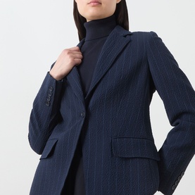 Model wearing Max Mara Main ultramarine pinstripe wool blazer jacket, styled with a black roll-neck top.