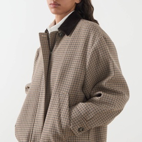 Model wearing Max Mara Weekend Festa Check Print Bomber Jacket in brown small check with dark corduroy collar, styled with white shirt underneath.