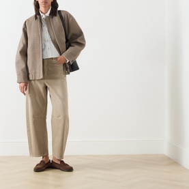 Model wearing Max Mara Weekend Festa Check Print Bomber Jacket in brown, styled with beige trousers, white shirt, and dark crossbody bag.