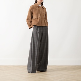 Model wearing Max Mara Weekend hazelnut goat leather jacket with wide-leg grey trousers and white top.