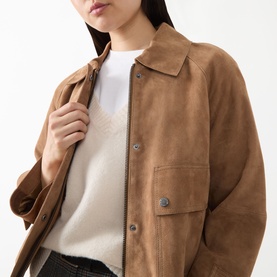 Model wearing Max Mara Weekend hazelnut suede goat leather jacket with collar, zip and snap buttons, styled with white knit top.