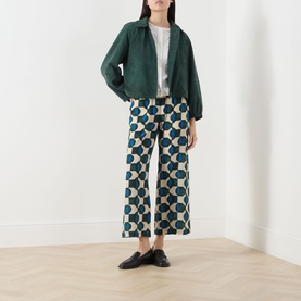 Model wearing Max Mara Weekend Zuppa Suede Jacket in dark green with point collar and front zip, styled with geometric print wide-leg trousers and