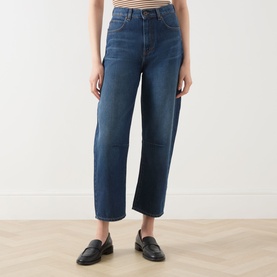 Model wearing dark blue high-waisted straight-leg jeans, styled with a striped top and black loafers