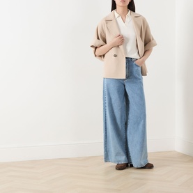 Model wearing Max Mara Weekend Zattera Wide Leg Jeans in blue, styled with a beige cropped jacket and white shirt.