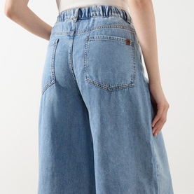 Model wearing Max Mara Weekend Zattera Wide Leg Jeans in blue, showing rear view with elasticated waistband, five-pocket style and logo detail