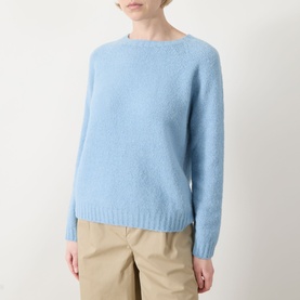 Model wearing Max Mara Weekend Ghiacci Knitted Sweater in light blue with crew neck and ribbed trims, styled with beige trousers.