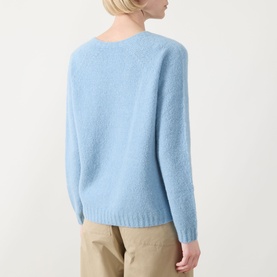 Model wearing Max Mara Weekend Ghiacci Knitted Sweater in light blue, shown from back, styled with beige trousers