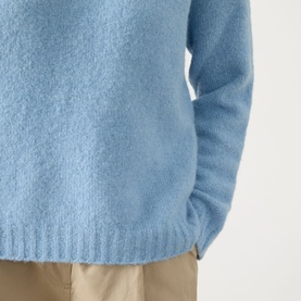 Model wearing Max Mara Weekend Ghiacci Knitted Sweater in light blue, showing ribbed hem detail, styled with beige trousers