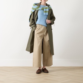 Model wearing Max Mara Weekend Ghiacci Light Blue Knitted Sweater with green checked scarf, khaki wide-leg trousers and brown loafers.