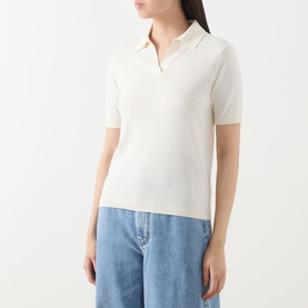 Model wearing Max Mara Weekend Roncolo Knit Polo Shirt in ecru, with flat collar, short sleeves and ribbed trims, styled with blue wide-leg jeans